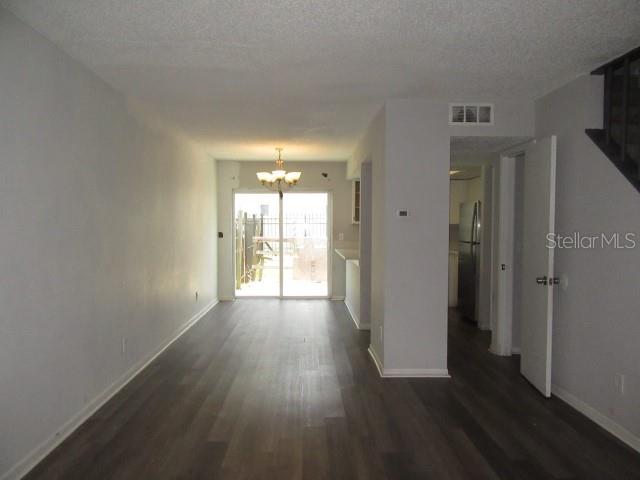 A living room with gray walls and wood-look flooring leads to a sliding glass door — 13042 LONDONDARY PLACE, TAMPA, FL
