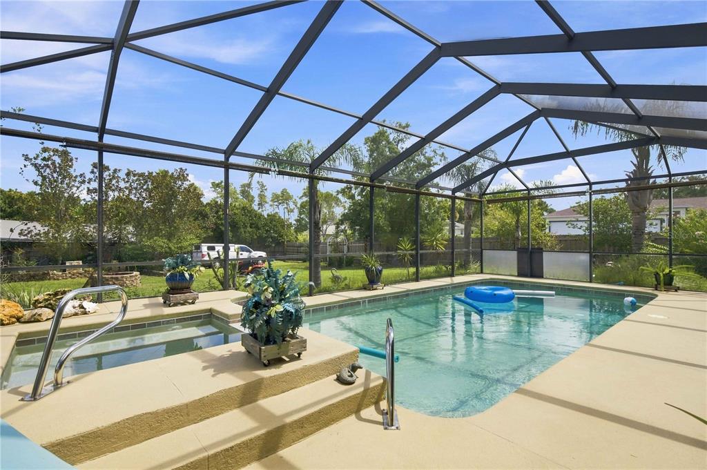 A screened-in patio features a swimming pool, a small hot tub, and a concrete deck — 4505 SW 106TH PLACE, OCALA, FL