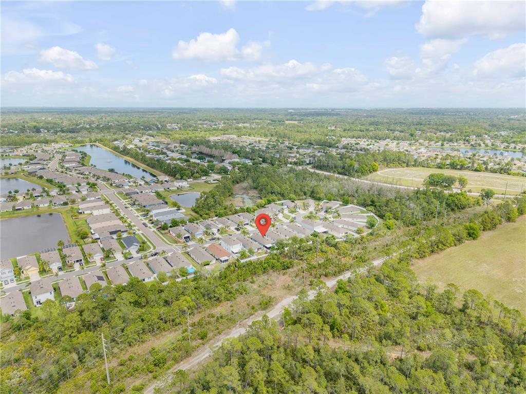 An aerial view shows a residential neighborhood with a red location pin on a house — 2820 TATON TRACE, NEW SMYRNA BEACH, FL