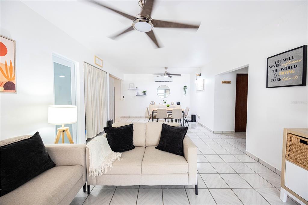 A living room with light-colored tile floors, a beige sofa, and a dining area beyond — Bo. Tierras Nuevas COLINAS DEL NORTE UNIT BB-1, MANATI, PR