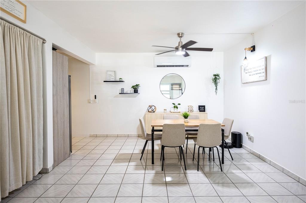 A dining room features a wooden table, four chairs, a sideboard, and tiled flooring — Bo. Tierras Nuevas COLINAS DEL NORTE UNIT BB-1, MANATI, PR