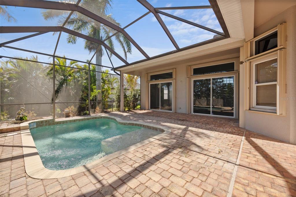 A screened-in patio features a small swimming pool and brick paver flooring — 2727 NW 45TH PLACE, CAPE CORAL, FL