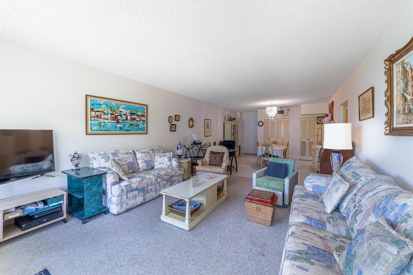 A living room with two patterned sofas, a coffee table, and a dining area beyond — 3450 S Ocean Boulevard # 206, Palm Beach FL 33480, PALM BEACH, FL