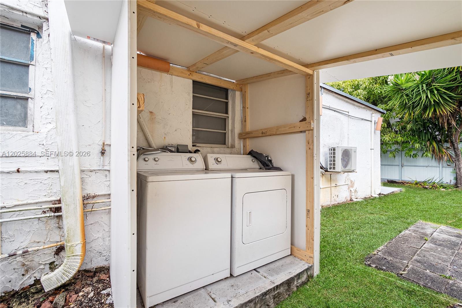 A washer and dryer are housed in an outdoor, partially covered wooden structure — 2255 SW 10th St # B, Miami FL 33135, MIAMI, FL