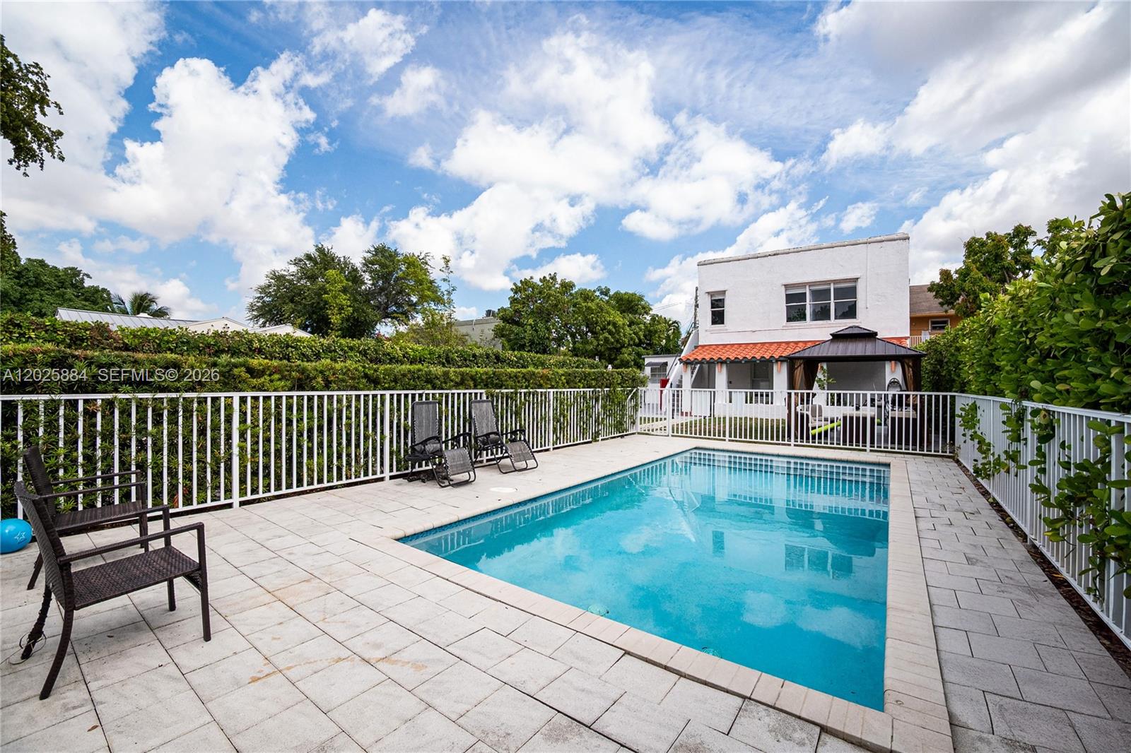 A rectangular swimming pool is surrounded by a paved patio and white metal fencing — 2255 SW 10th St # B, Miami FL 33135, MIAMI, FL