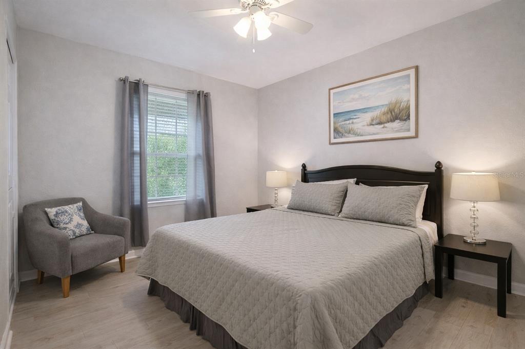 A bedroom features a bed with grey bedding, a grey armchair, and two bedside lamps — 501 S MAGNOLIA AVENUE UNIT 4, TAMPA, FL