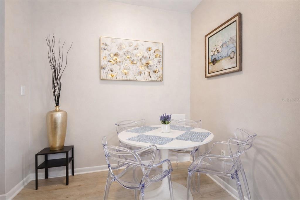 A small dining area features a white round table, four clear chairs, and wall art — 501 S MAGNOLIA AVENUE UNIT 4, TAMPA, FL