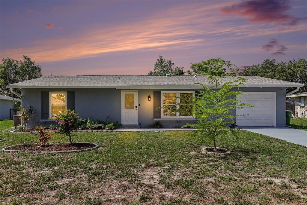 A single-story gray house with a white front door, shutters, and an attached garage — 837 DOLPHIN AVENUE NW, PORT CHARLOTTE, FL