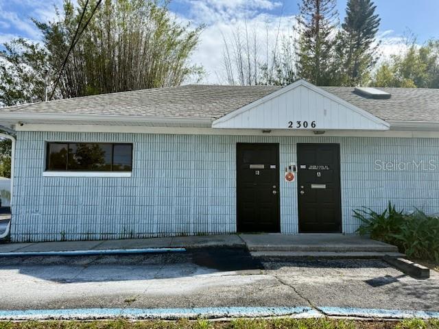 The exterior of a single-story building features light blue siding, two dark doors, and a window — 2306 LEE ROAD, WINTER PARK, FL