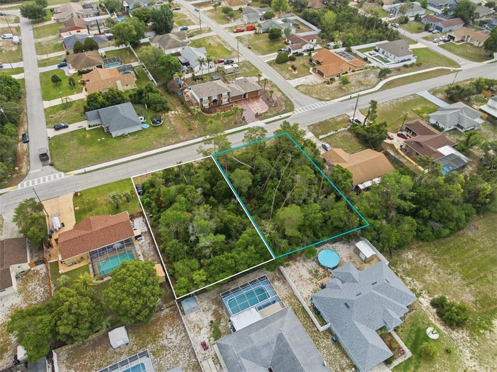 An aerial view shows two adjacent wooded vacant lots outlined in a residential neighborhood — 6019 FREEPORT DRIVE, SPRING HILL, FL