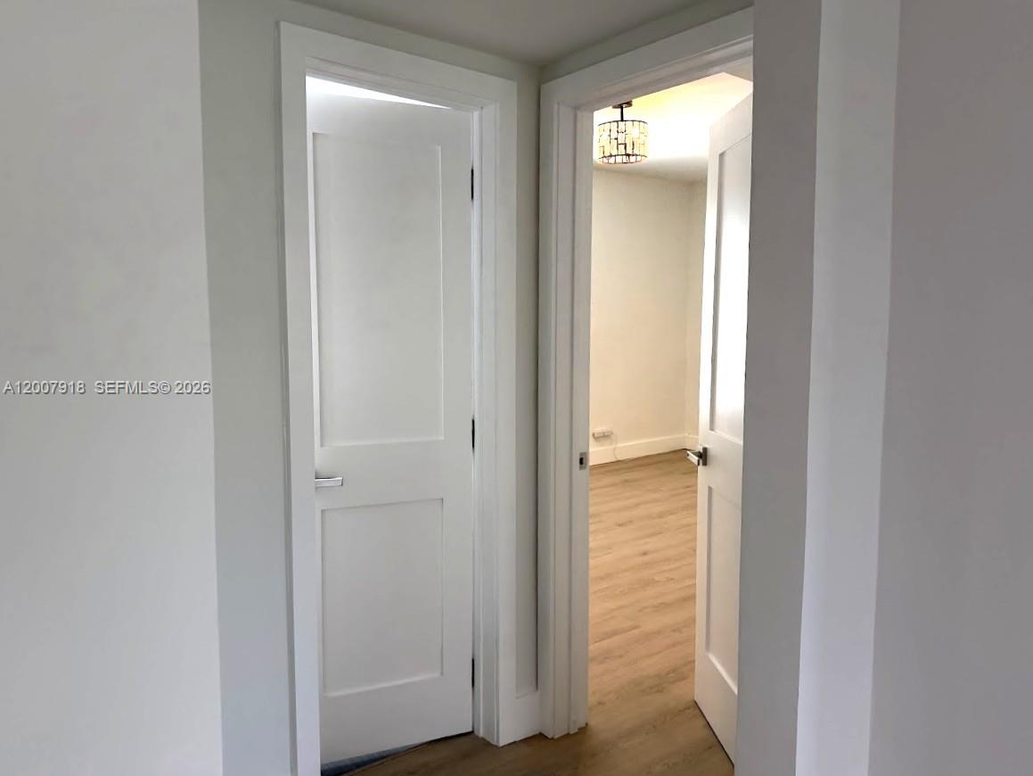 Two white interior doors open into a room with light wood-look flooring and lighting — 2272 SW 13th St, Miami FL 33145, MIAMI, FL