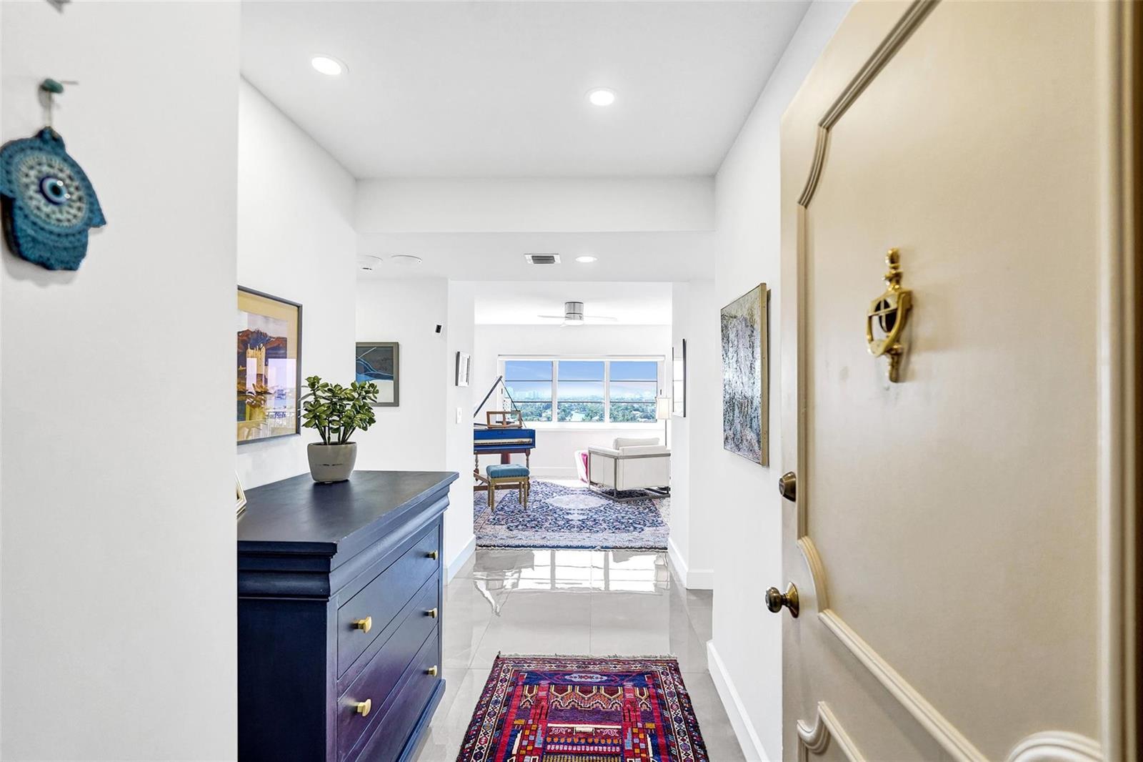 A view from an entryway into a living area featuring a piano and large windows — 2500 E Las Olas Boulevard # 1509, Fort Lauderdale FL 33301, FORT LAUDERDALE, FL