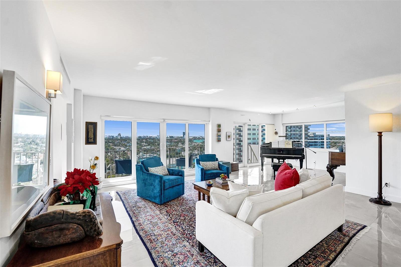 A bright living room features a white sofa, blue armchairs, a grand piano, and balcony views — 2500 E Las Olas Boulevard # 1509, Fort Lauderdale FL 33301, FORT LAUDERDALE, FL