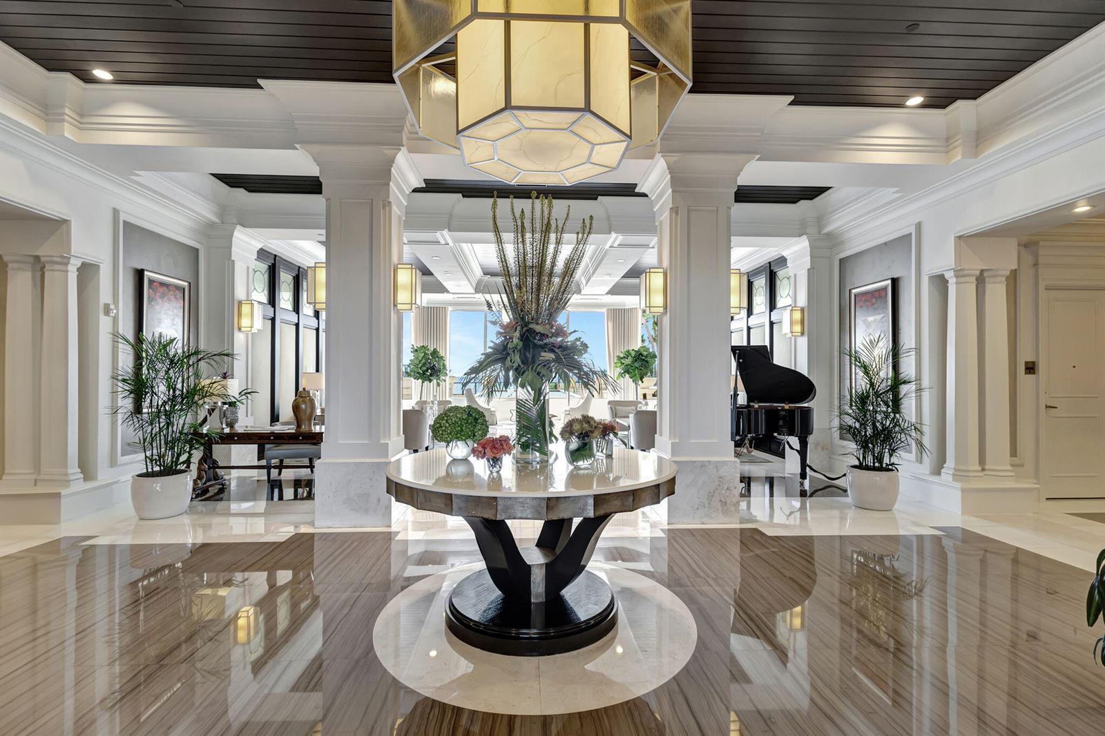 A grand lobby features a central marble table, a large chandelier, and a grand piano — 2700 N Ocean Drive # 804a, Riviera Beach FL 33404, RIVIERA BEACH, FL