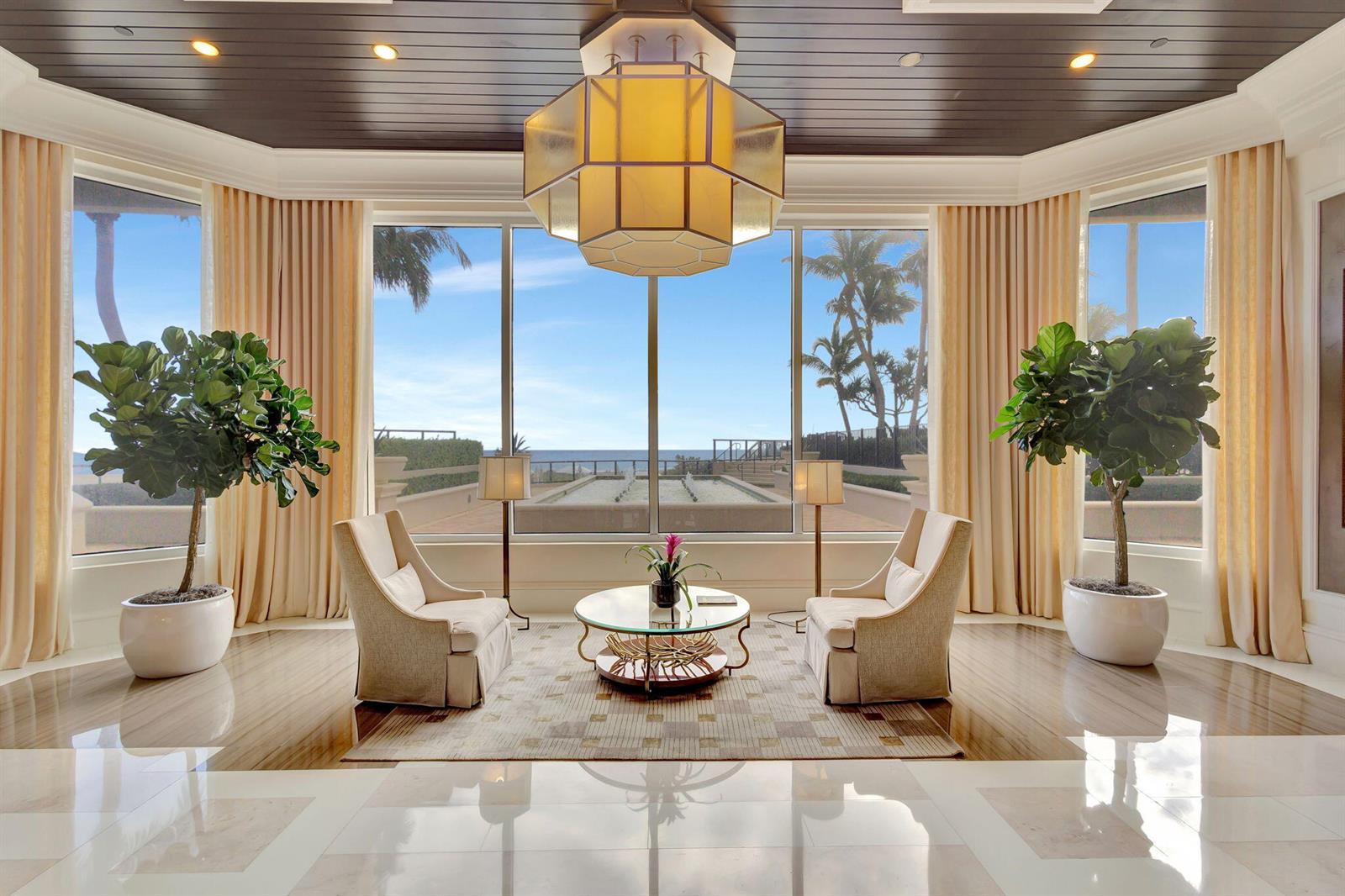 A symmetrical seating area features two armchairs, a glass coffee table, and large ocean-view windows — 2700 N Ocean Drive # 804a, Riviera Beach FL 33404, RIVIERA BEACH, FL
