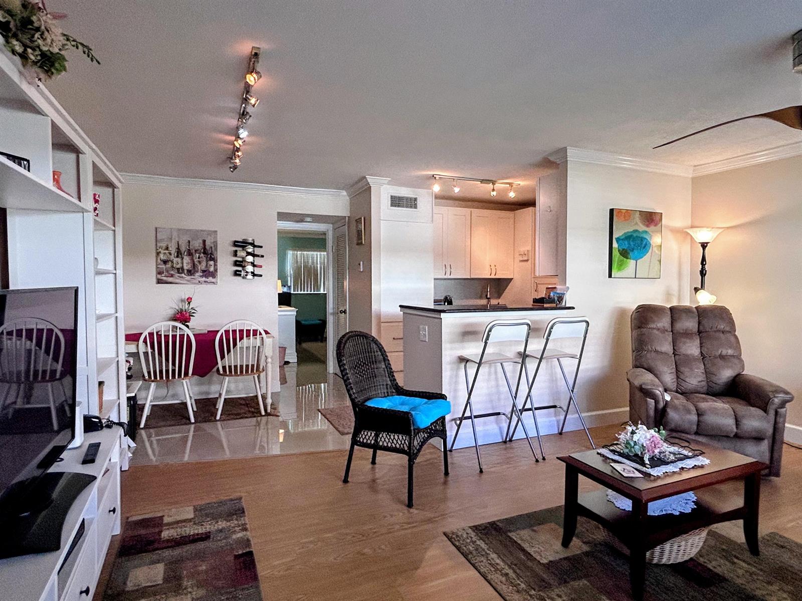An open-concept living and dining area features a kitchen island, tile flooring, and neutral walls — 638 Snug Harbor Drive # E6, Boynton Beach FL 33435, BOYNTON BEACH, FL