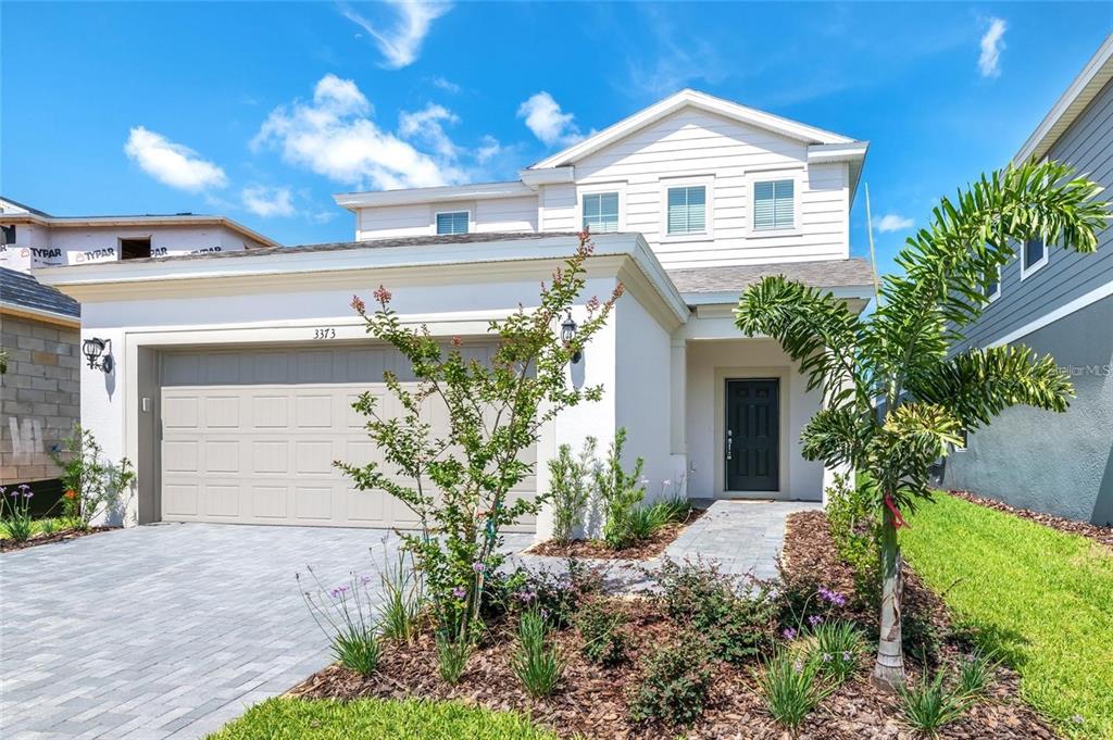 A two-story house with a white exterior, a two-car garage, and a front walkway — 3373 LILAC WAY, DAVENPORT, FL