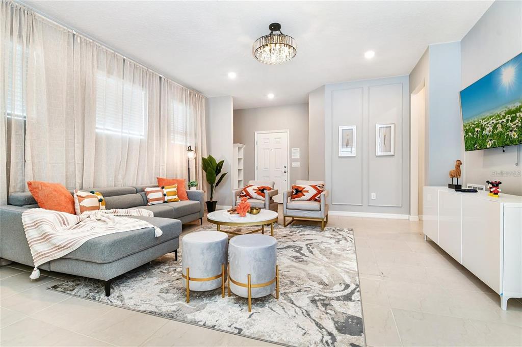 A living room features a grey sectional sofa, two armchairs, and a patterned area rug — 3373 LILAC WAY, DAVENPORT, FL