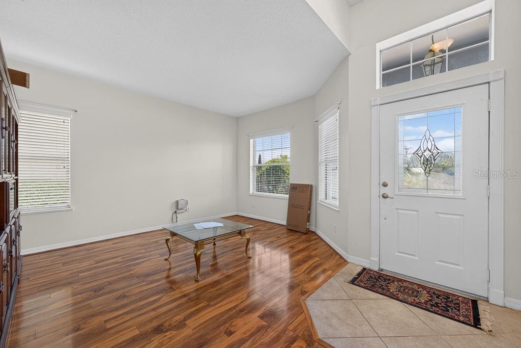An entryway with wood flooring, a glass coffee table, and a white front door — 3614 PLYMOUTH DRIVE, WINTER HAVEN, FL