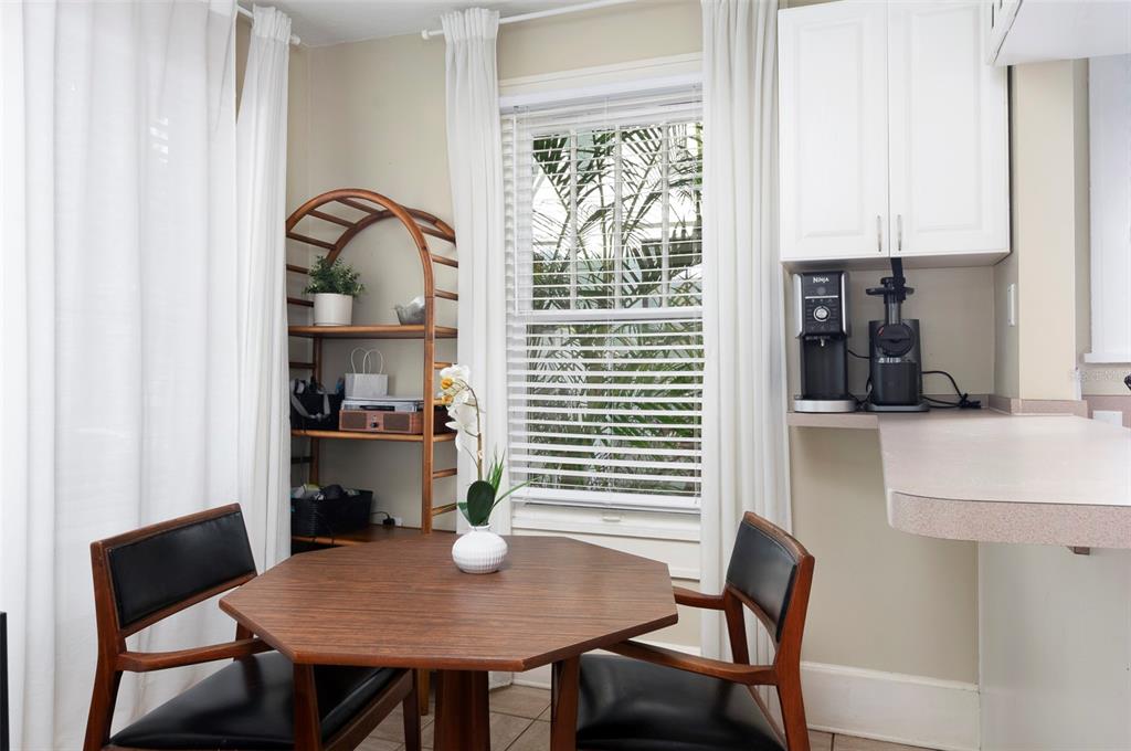 A dining area features an octagonal wooden table, two chairs, and a bamboo shelving unit — 540 11TH AVENUE N, ST PETERSBURG, FL