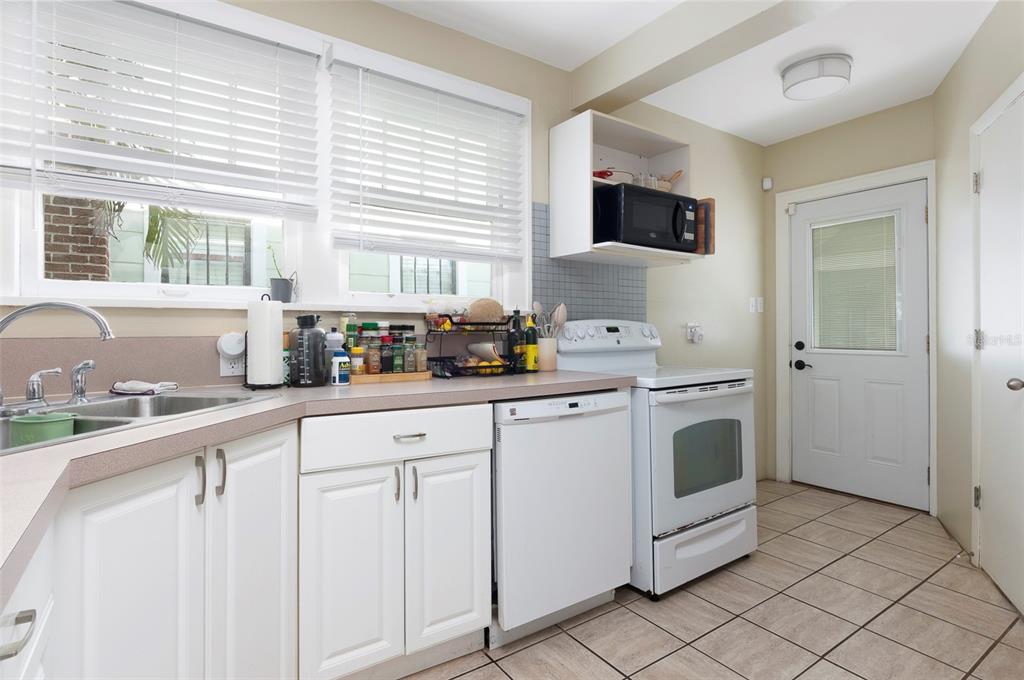 A kitchen features white cabinets, a dishwasher, a white stove, and a tiled floor — 540 11TH AVENUE N, ST PETERSBURG, FL