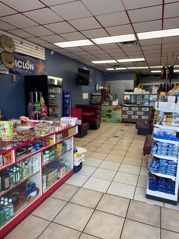 The interior of a small convenience store features a service counter, shelving, and booth seating — 131 BUENAVENTURA BOULEVARD UNIT 1A, KISSIMMEE, FL