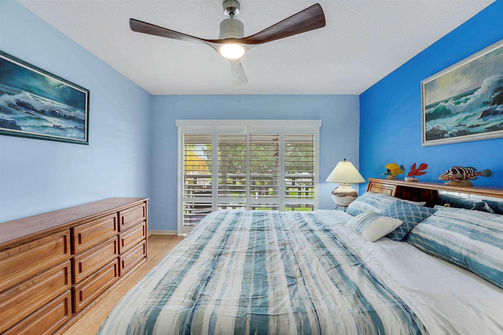 A bedroom features a wooden dresser, a bed with striped bedding, and blue walls — 331 Tequesta Drive # 213, Tequesta FL 33469, TEQUESTA, FL