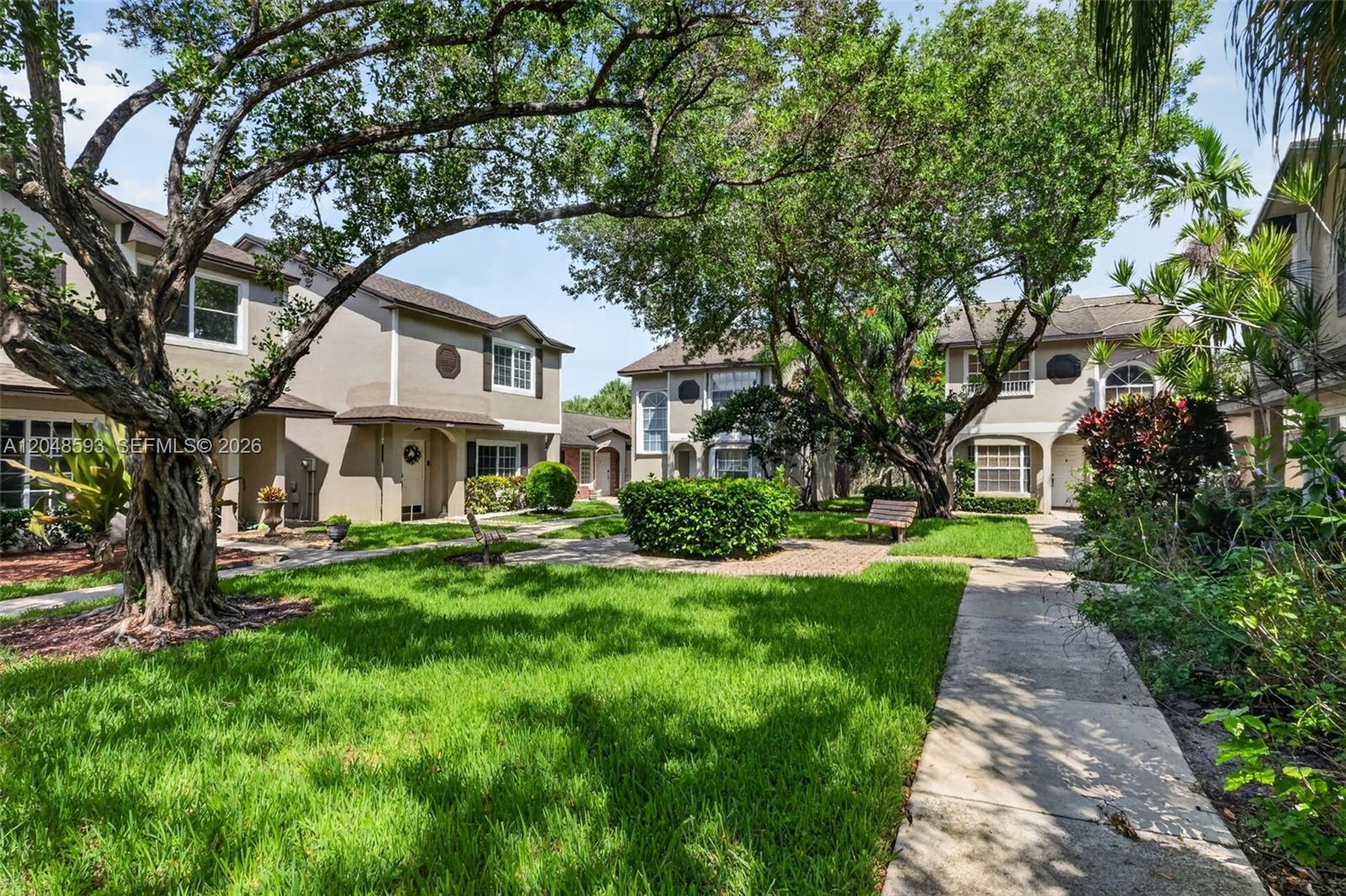 A grassy courtyard with mature trees and paved walkways sits between two-story residential buildings — 3835 NW 122nd Ter, Sunrise FL 33323, SUNRISE, FL