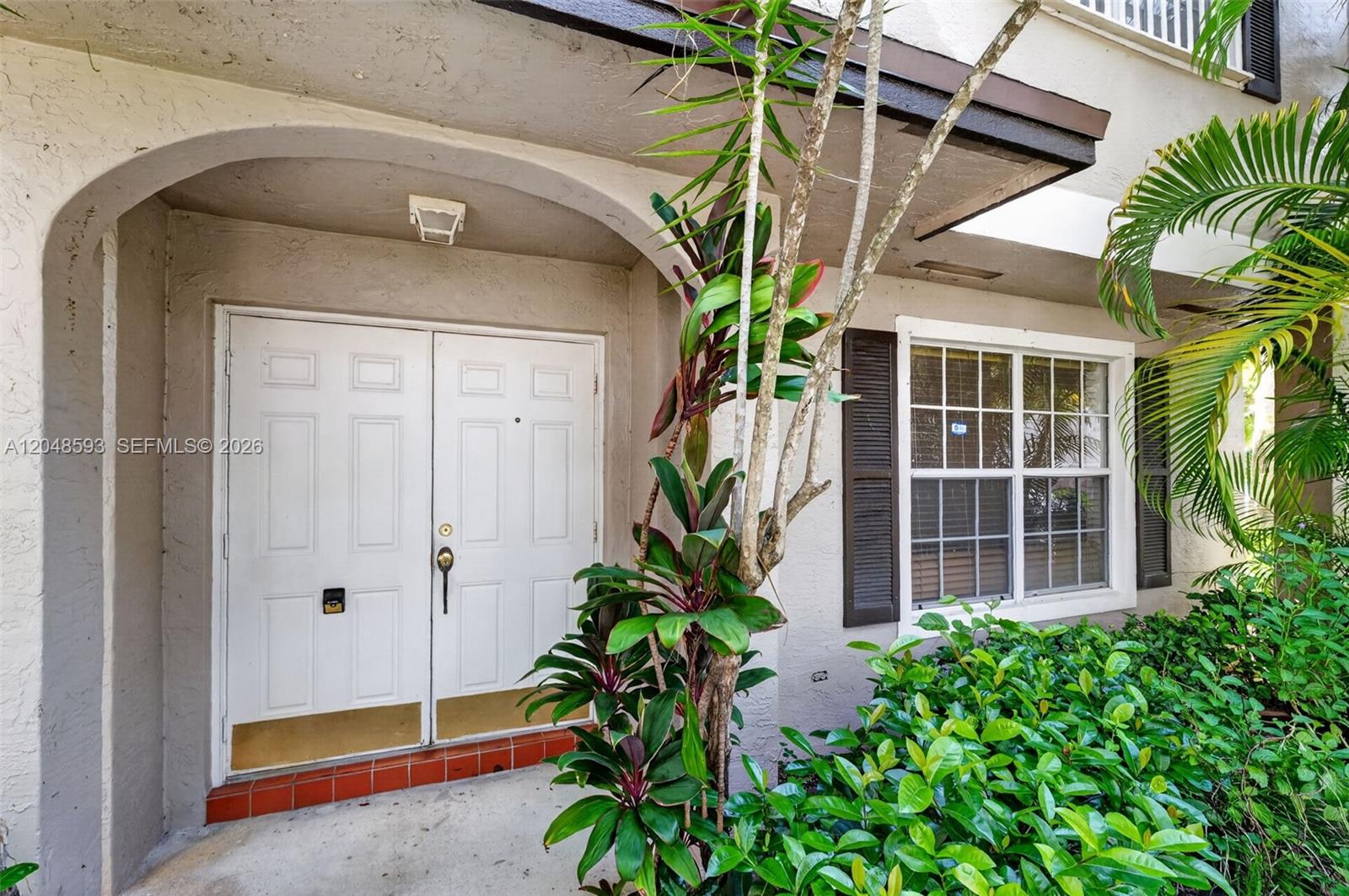 A white double front door with a gold kickplate sits under an arched entryway — 3835 NW 122nd Ter, Sunrise FL 33323, SUNRISE, FL