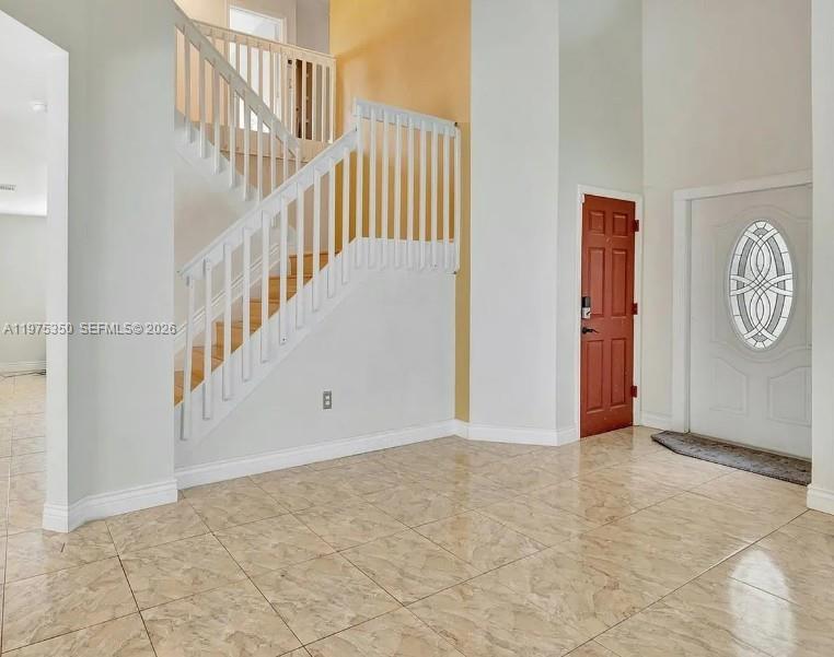 An entryway features a tiled floor, a white staircase with railings, and two doors — 10207 SW 20th Ct, Miramar FL 33025, MIRAMAR, FL