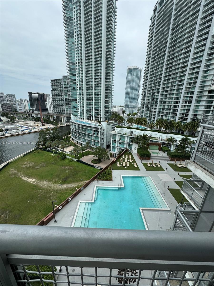 An elevated view of a swimming pool deck, a grassy lot, and surrounding high-rise buildings — 350 S Miami Ave # 1704, Miami FL 33130, MIAMI, FL