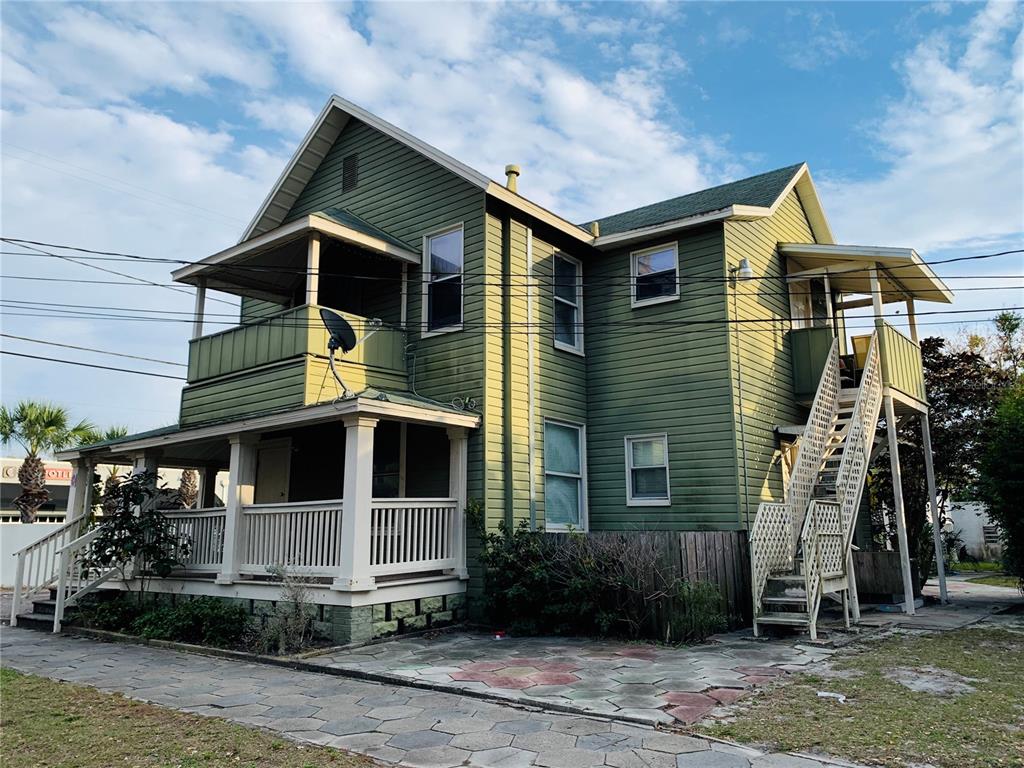A two-story green house with a front porch, a balcony, and an exterior metal staircase — 432 8TH AVENUE N UNIT 2, ST PETERSBURG, FL