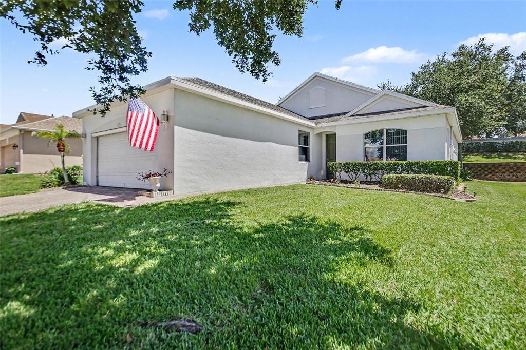 A single-story house with a white exterior, a two-car garage, and a front lawn — 2361 PRAIRIE DUNES, CLERMONT, FL