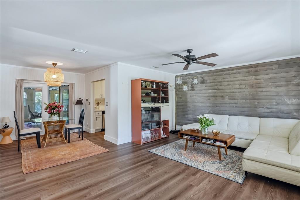 A living and dining area features wood-look flooring, a shiplap accent wall, and white furniture — 220 45TH AVENUE S, ST PETERSBURG, FL