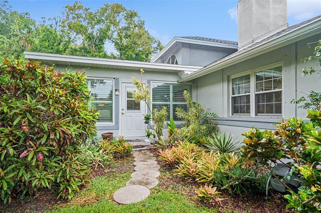 A spacious living room features a stone fireplace, vaulted ceilings, and light wood flooring — 2950 ST ANDREWS BOULEVARD, TARPON SPRINGS, FL