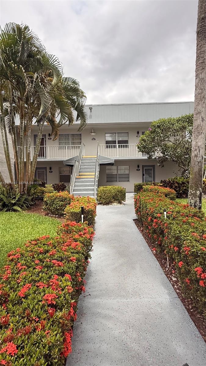 A concrete walkway leads to the stairs of a two-story apartment building with landscaping — 322 Piedmont G # G, Delray Beach FL 33484, DELRAY BEACH, FL