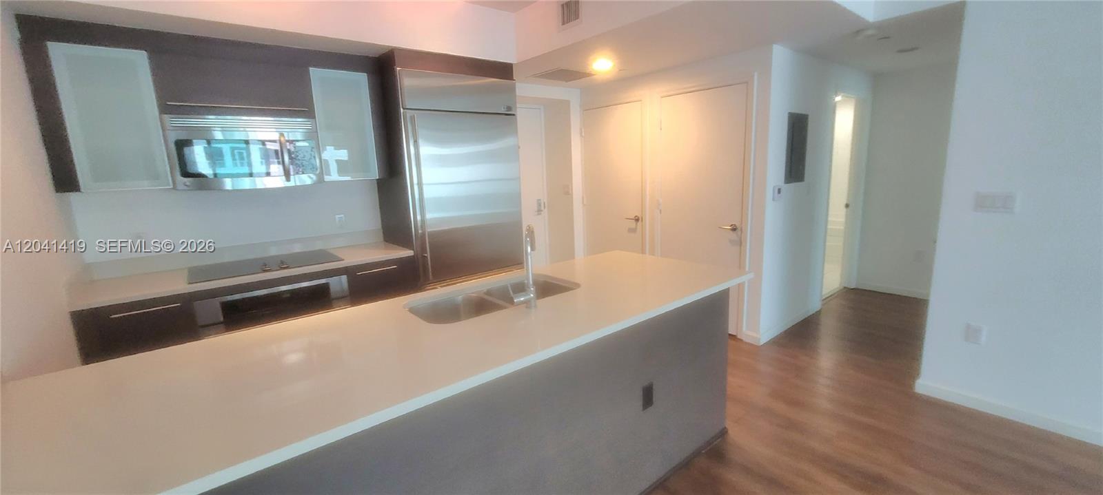 A modern kitchen features a large island, stainless steel appliances, and light-colored countertops — 500 Brickell Ave # 3706, Miami FL 33131, MIAMI, FL