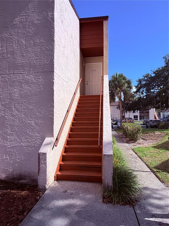 An exterior view of a staircase leading to an apartment entrance with a white door — 2527 CITRUS CLUB LANE UNIT 3904, ORLANDO, FL