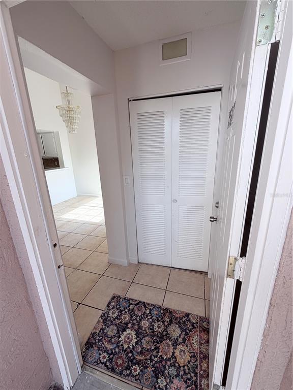 A kitchen features white cabinets, tan tile flooring, a white stove, and a stainless sink — 2527 CITRUS CLUB LANE UNIT 3904, ORLANDO, FL