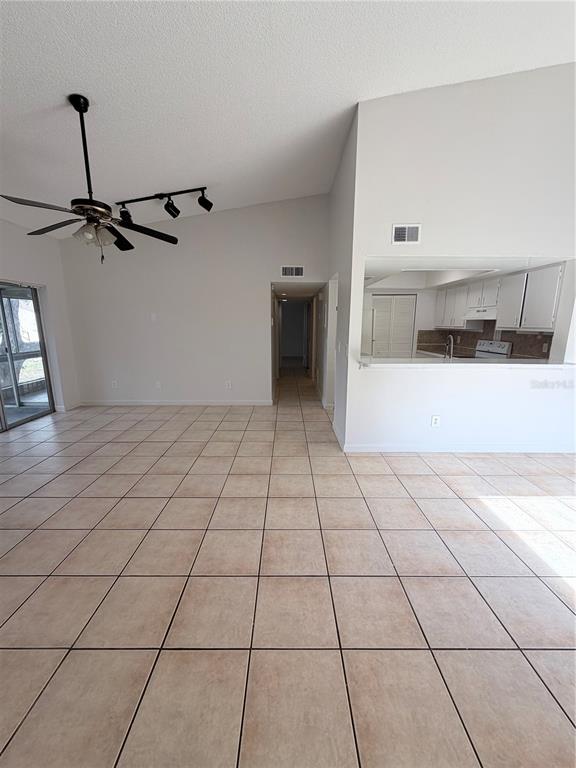 An empty room features light-colored walls, a ceiling fan, and brown tiled flooring — 2527 CITRUS CLUB LANE UNIT 3904, ORLANDO, FL