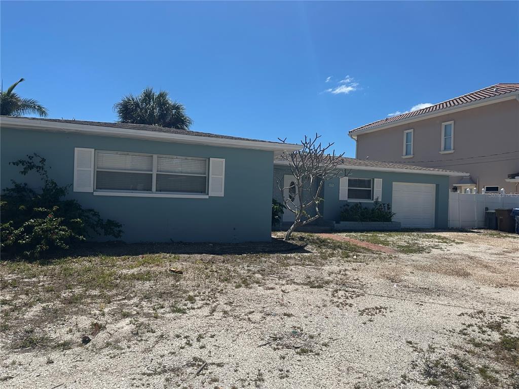 A single-story blue house with a white garage and a large gravel front yard — 7112 S SHORE DRIVE S, SOUTH PASADENA, FL