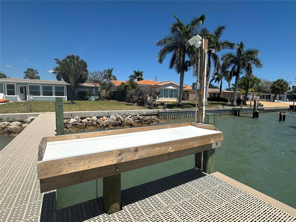 A wooden fish cleaning station sits on a dock overlooking a canal and houses — 7112 S SHORE DRIVE S, SOUTH PASADENA, FL