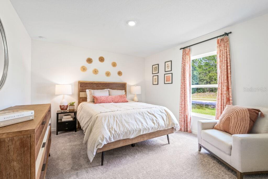 A bedroom features a wooden bed frame, a dresser, a chair, and a window — 444 PATRICIA ALFORD DRIVE, HAINES CITY, FL