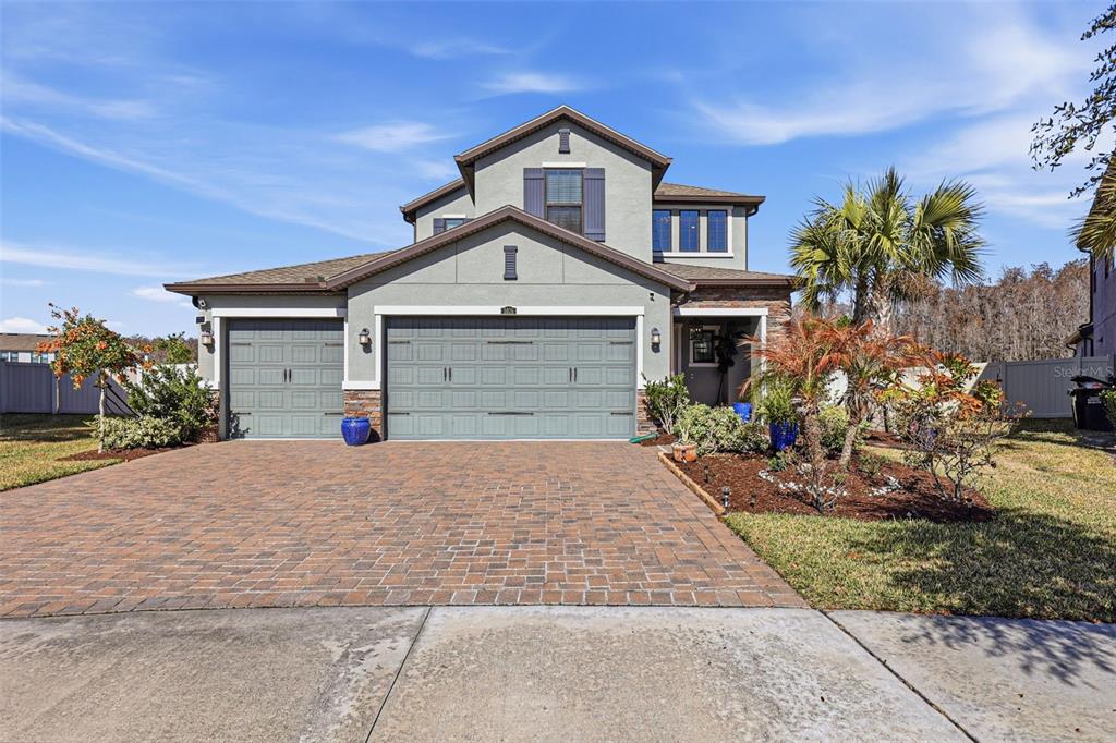 An aerial view shows a single-family home situated on a waterfront lot in a subdivision — 5026 TIVOLI DRIVE, WESLEY CHAPEL, FL
