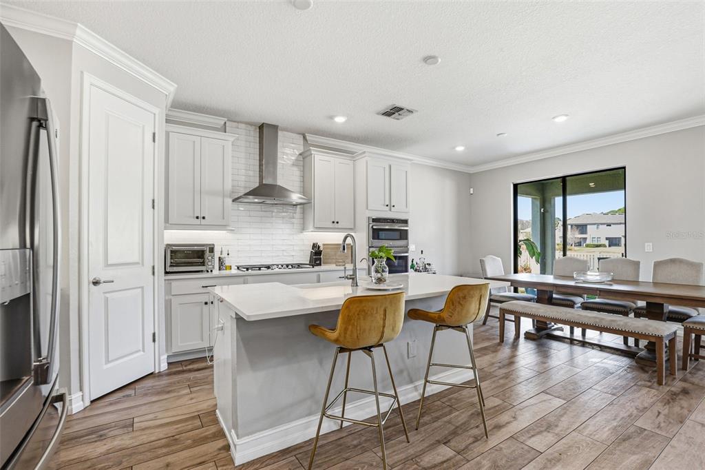 A two-story house with a three-car garage and a paved driveway at sunset — 5026 TIVOLI DRIVE, WESLEY CHAPEL, FL