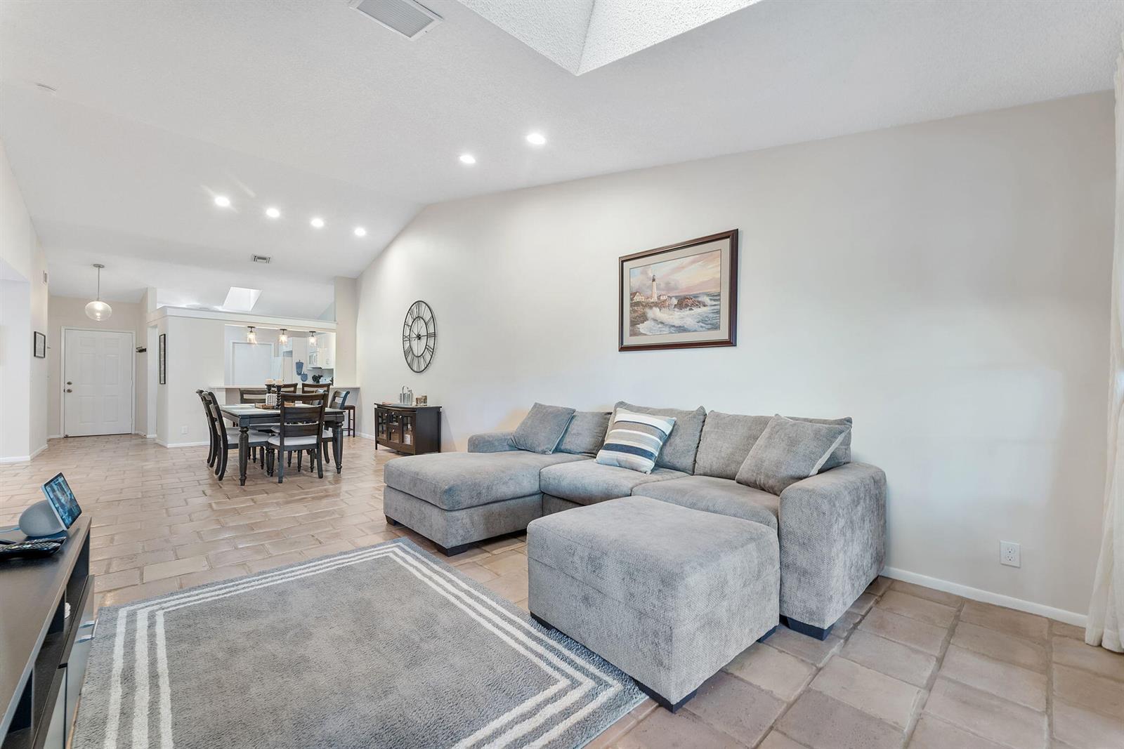 A living room features a gray sectional sofa, a rug, and an adjacent dining area — 5861 Sunswept Lane # B, Boynton Beach FL 33437, BOYNTON BEACH, FL