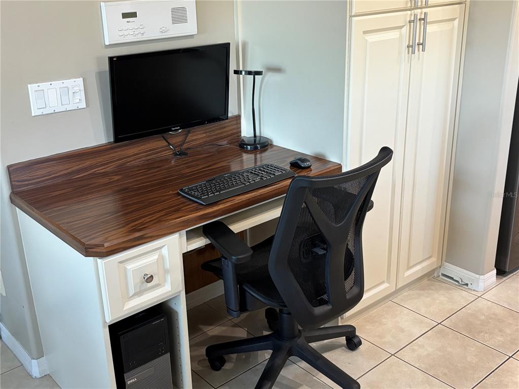 A home office nook features a wood-grain desk, a black computer, and a mesh chair — 152 NAUTICA MILE DRIVE, CLERMONT, FL