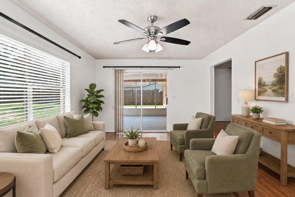 A living room with a beige sofa, two green armchairs, a coffee table, and ceiling fan — 1285 N HAGGERTY POINT, CRYSTAL RIVER, FL