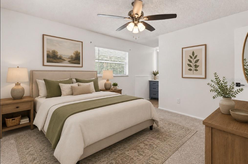 This virtually staged bedroom features a bed with olive green accents, a ceiling fan, and carpet — 1285 N HAGGERTY POINT, CRYSTAL RIVER, FL