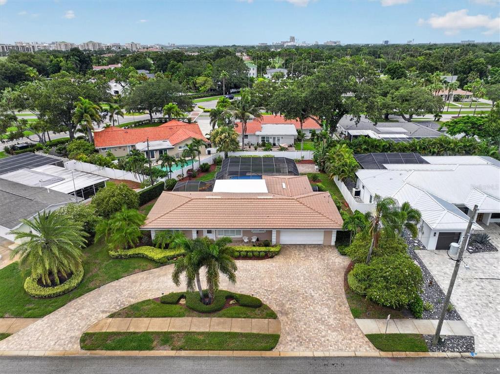 An aerial view shows a single-story house with a tiled roof and a paved driveway — 802 OSCEOLA ROAD, BELLEAIR, FL